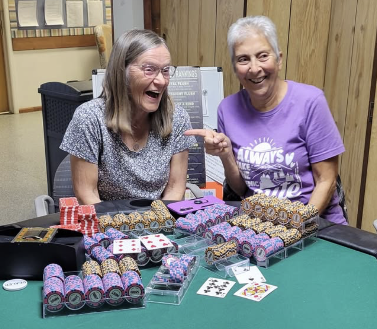 Two smiling leaseholders at the Free Poker Tournament, surrounded by stacks of poker chips.